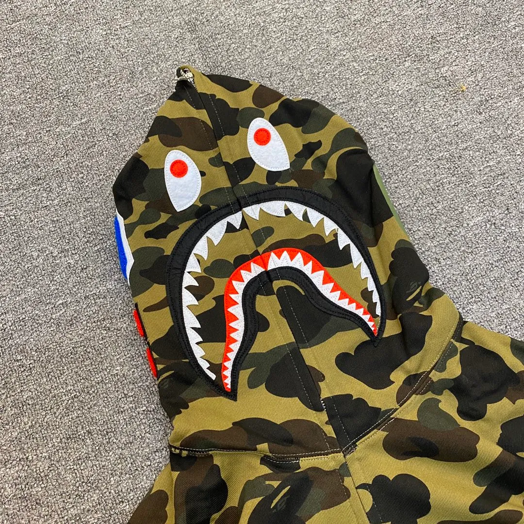XX 121 BAPE 1ST CAMO SHARK FULL Classic counter model Camouflage shark hooded zipper sweatshirt Machine-printed camouflage Top-quality fabric Premium 1:1 replica Customized fabric Couple model: S—XXL [Camouflage yellow, Camouflage green, Camouflage red, Camouflage purple, Camouflage blue, Camouflage gray]
